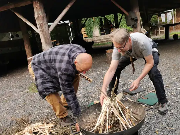 Pfarrer und Kollege zeigen wie Holz vorbereitet wird